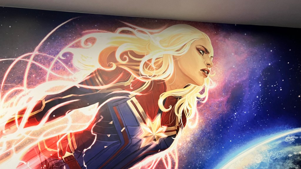 A picture of Artwork depicting Captain Marvel flying in space above Earth in a blaze of light